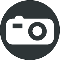 Picto rond gris foncé avec un appareil photo blanc au centre