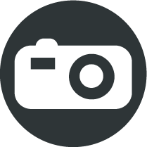 Picto rond gris foncé avec un appareil photo blanc au centre